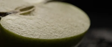 Half an apple lies on a dark surface in contrasting light Stock Footage 106011482