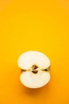 Half of apple on the yellow background with copy space Stock Photos