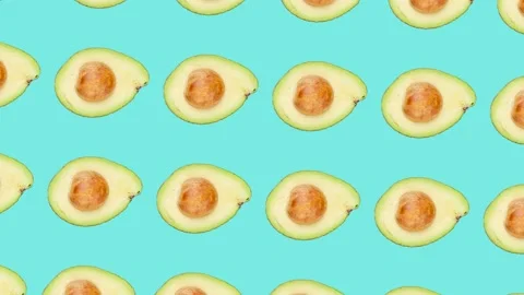 A half of Avocado fruit with seed in seamless loop pattern on a blue background Stock Footage 222327242