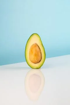 Half avocado fruit on white table Stock Photos