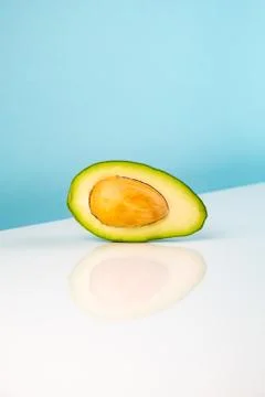 Half avocado fruit on white table Stock Photos