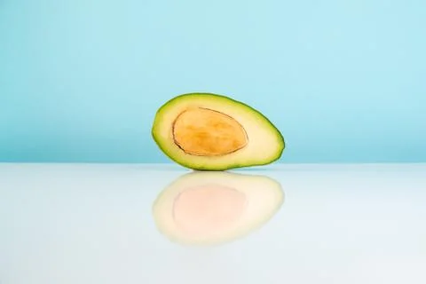 Half avocado fruit on white table Stock Photos