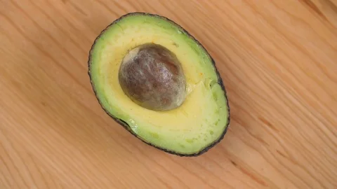 Half an Avocado with nut spinnin on cutting board 02 Stock Footage 110886936