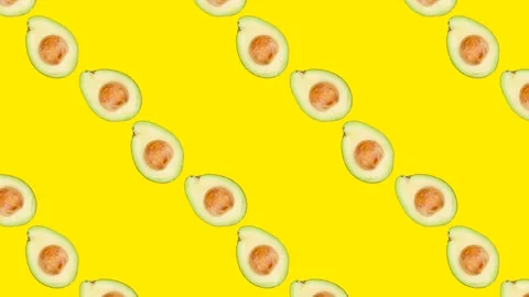 A half of Avocado with seed in seamless loop pattern on a yellow background Stock Footage 222325035