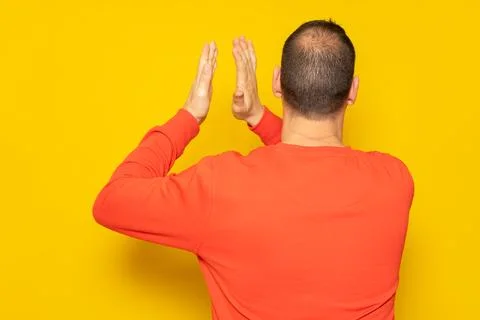 Half-bald man energetically clapping his back, he is excited about the spec.. Stock Photos