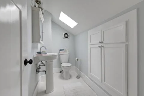 Half bathroom interior with skylight in the attic. View of toilet and washbas Fotos de archivo