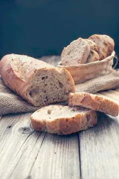 Half bread and slices of it in a basket Stock Photos