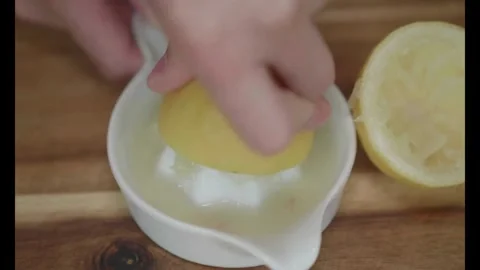 Half of bright ripe lemon is pressed on and fresh juice flows down. Healthy Stock-Footage 336588638