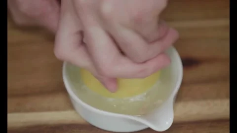 Half of bright ripe lemon is pressed on and fresh juice flows down. Healthy Stock-Footage 336588673