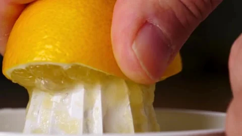 Half of bright ripe lemon is pressed on and fresh juice flows down. Healthy Stock-Footage 336588730