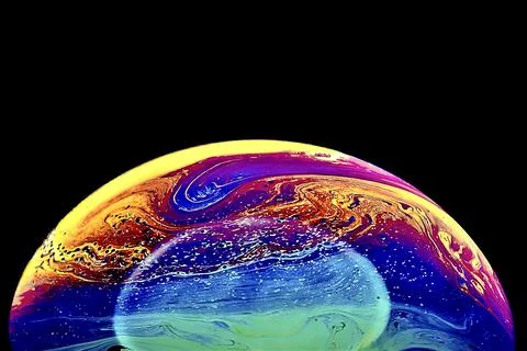 Half bubble with colorful abstract patterns on a dark background Stock Photos