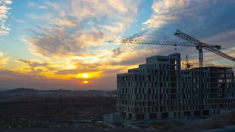 Half-built building with cranes against romantic sunset. 4K Time Lapse video. Stock Footage 259301192