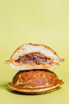 Half of burger with no top bread isolated on pastel yellow background Stock Photos