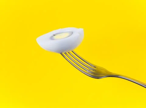 Half of a chicken egg on a fork close-up. Stock Photos