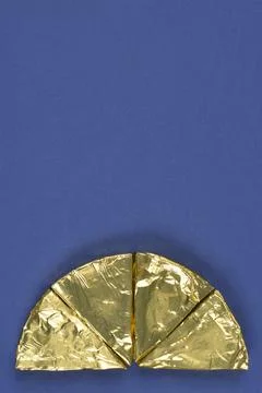 Half circle of triangular cheese portions in gold foil Stock Photos