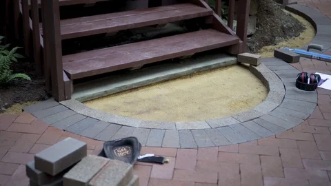 Half circle two-tone brick pattern under construction on the patio. Stock Footage 81574178