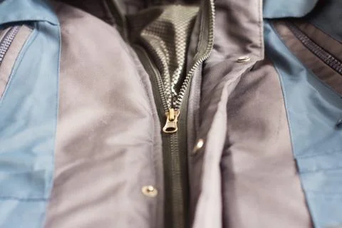 A half-closed sewing lock on a winter grey synthetic jacket. Stock Photos