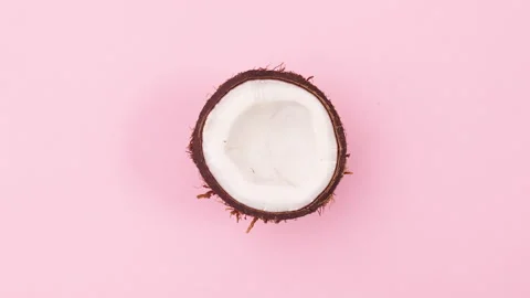 Half coconut move in circle. Spinning coconut on pink theme. Stop motion 動画素材 147105370