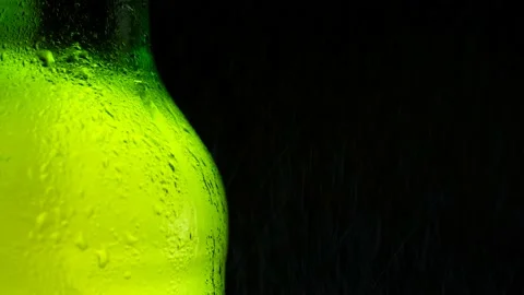 Half a cold green bottle of fresh and refreshing beer is sprayed with water. Stock Footage 154709633