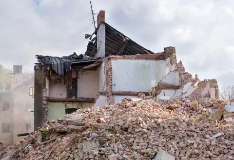 Half collapsed brick house covered in dust and debris Stock Photos