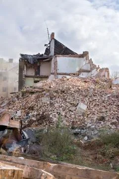 Half collapsed brick house covered in dust and debris Foto stock