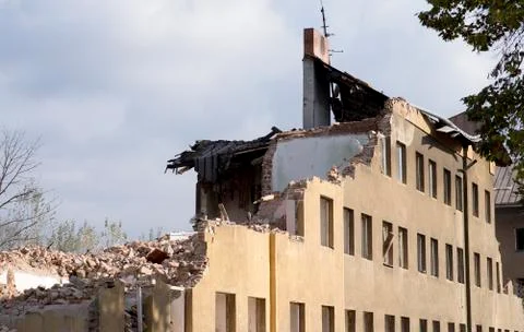 Half collapsed brick house covered in dust and debris Stock Photos