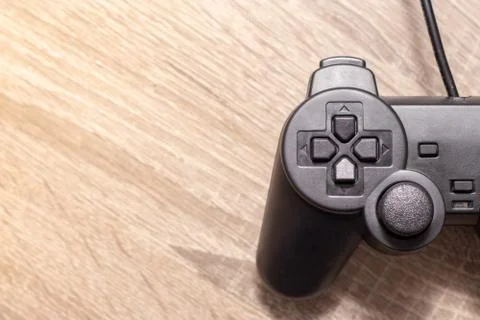 Half of a console video gaming controller on the right on wooden grey brown b Stock Photos