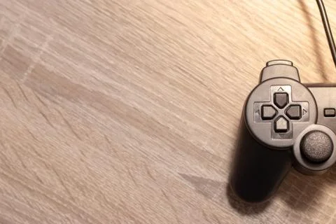 Half of a console video gaming controller on the right on wooden grey brown b Stock Photos