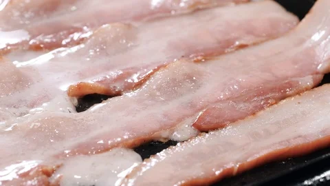 Half cooked bacon slices on the pan Stockbeeldmateriaal 102606741