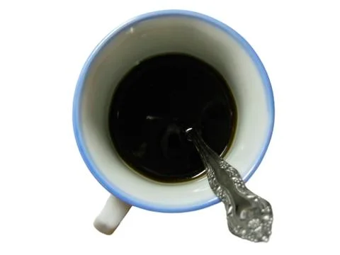 Half of cup black coffee with teaspoon inside isolated Stock Photos
