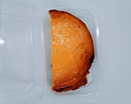 Half a curd pie. half of curd cake in a plastic container on a white backgrou Stock Photos