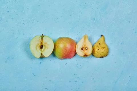 Half cut apple and pear isolated blue background Stock Photos