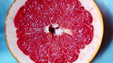 Half cut grapefruit or red orange rotating on metallic background Stock Footage 233254944