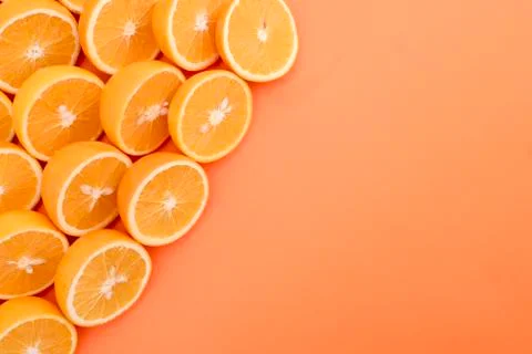 Half cut oranges in the corner of the orange background Stock Photos