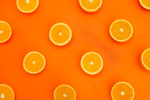 Half-cut oranges on orange background Stock Photos