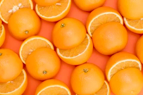Half-cut oranges on orange background close-up Stock Photos
