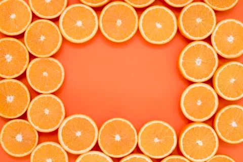 Half cut oranges on orange background with place in the middle for lettering Foto stock