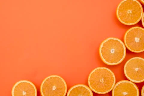 Half-cut oranges on orange background with space for inscriptions Stock Photos