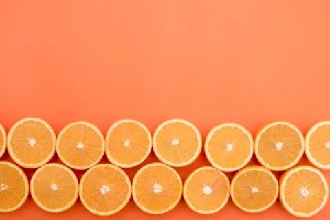 Half-cut oranges in two rows on an orange background Stock Photos