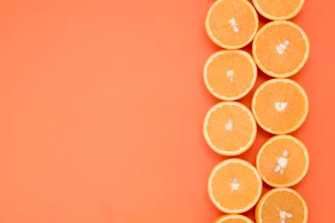 Half-cut oranges in two rows on the edge of the orange background Stock Photos