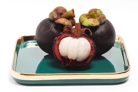 Half cut sliced and two whole fresh organic mangosteen delicious fruit in a.. Stock Photos
