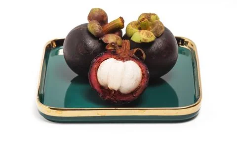 Half cut sliced and two whole fresh organic mangosteen delicious fruit in a.. Stock Photos