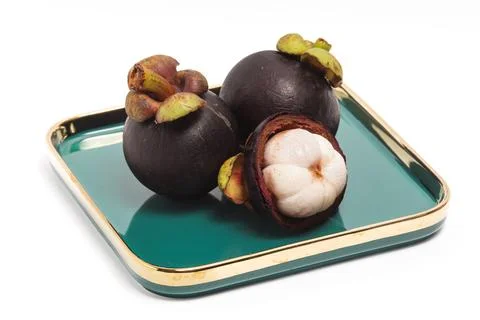 Half cut sliced and two whole fresh organic mangosteen delicious fruit in a.. Stock Photos
