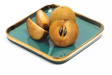 Half cut sliced and two whole fresh organic sapodilla delicious fruit in a .. Stock Photos