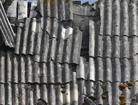 Half-destroyed slate on an old rustic roof, wreckage and dirty texture Stock Photos