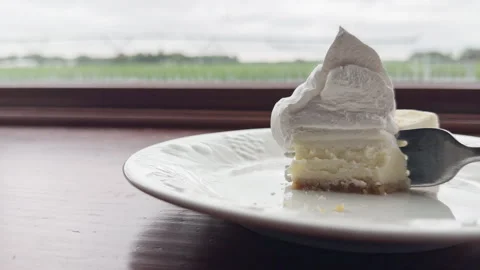 Half eaten cheesecake with fork slowly coming back for more Vídeos de archivo 339355651