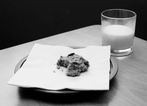 Half-eaten cookie with a half drunk glass of milk Stock Photos