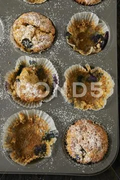 A half eaten tray of muffins Stock Photos