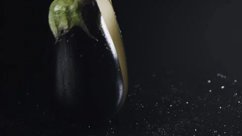 Half an eggplant falling on a black table in slow motion. Stock Footage 140498154