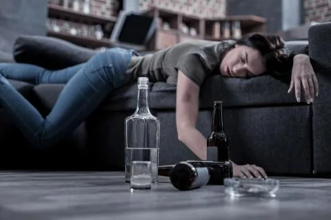 Half empty bottle of vodka standing on the floor Stock Photos